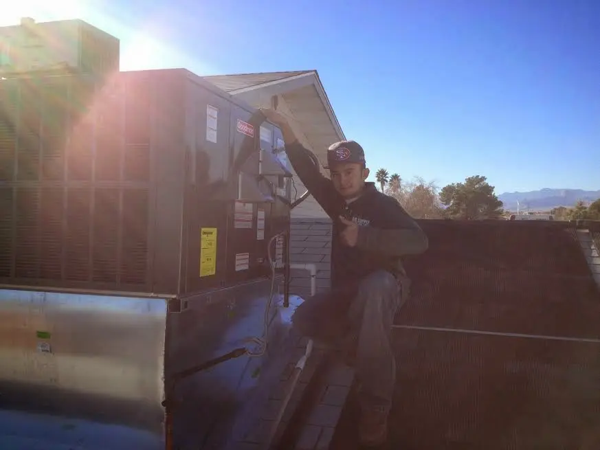 HVAC technician performing AC Tune-Up on a rooftop unit in Hurst